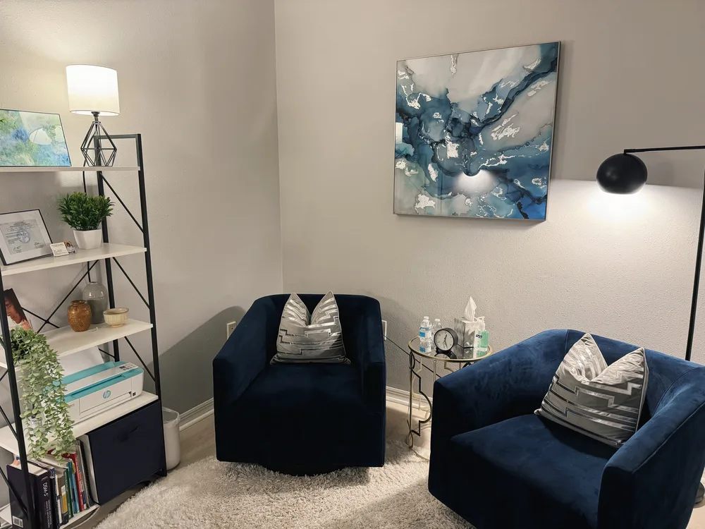 Zach Gibbs's therapy office at the Dr. Phillips location of Orlando Thrive Therapy, a calm space with navy chairs for counseling sessions.