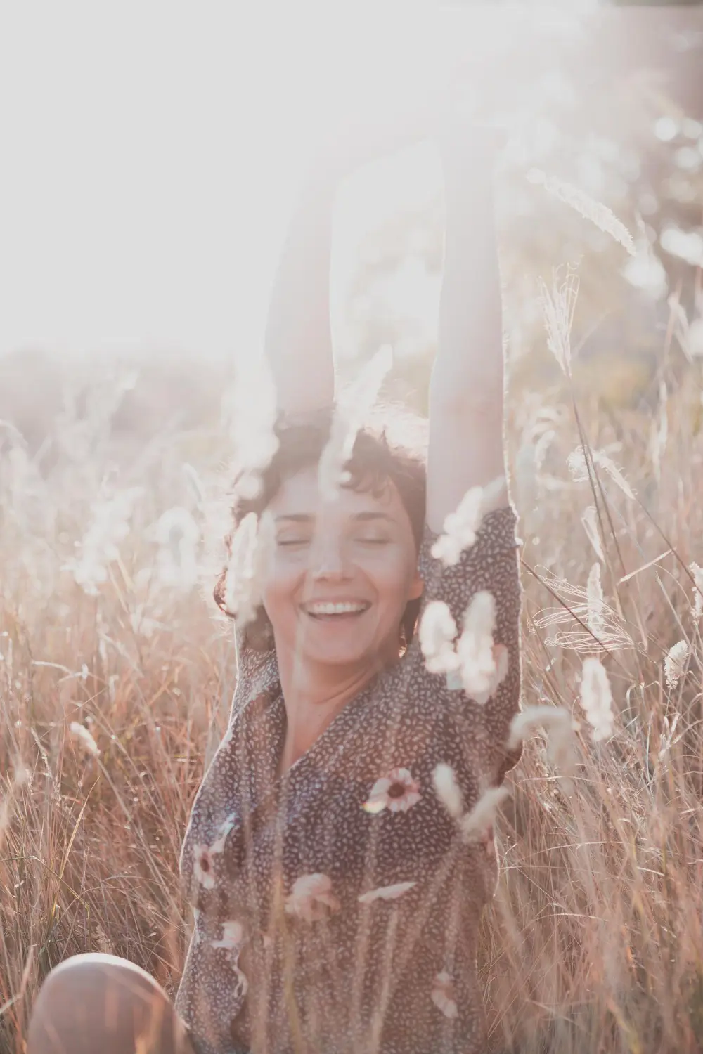 A happy woman embracing nature, reflecting the 'Thrive' mission of our Downtown Orlando therapists to help clients move beyond just surviving.