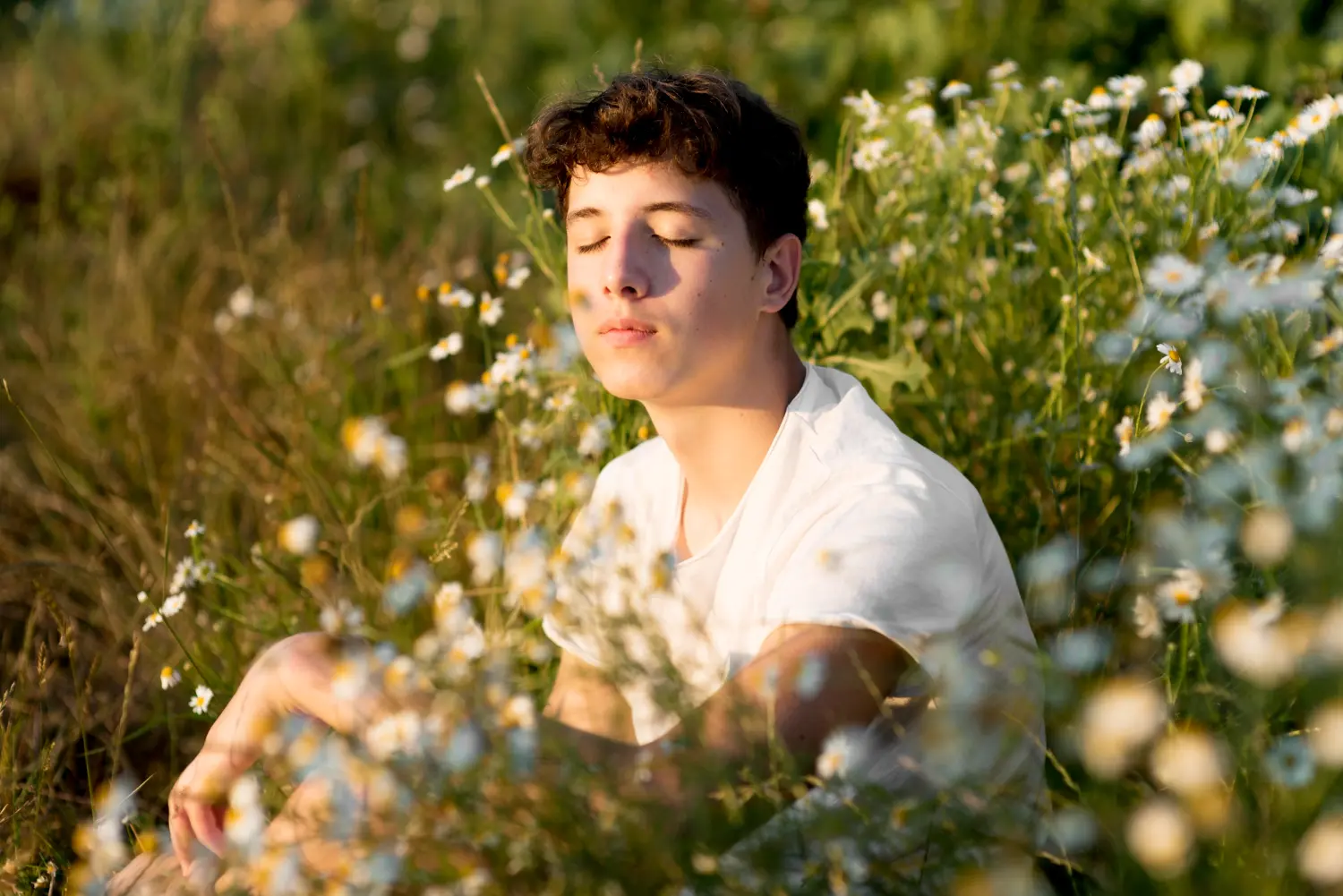 Man peacefully reflecting in nature with sunlight on his face, illustrating the restorative mental health support offered at Orlando Thrive Therapy.