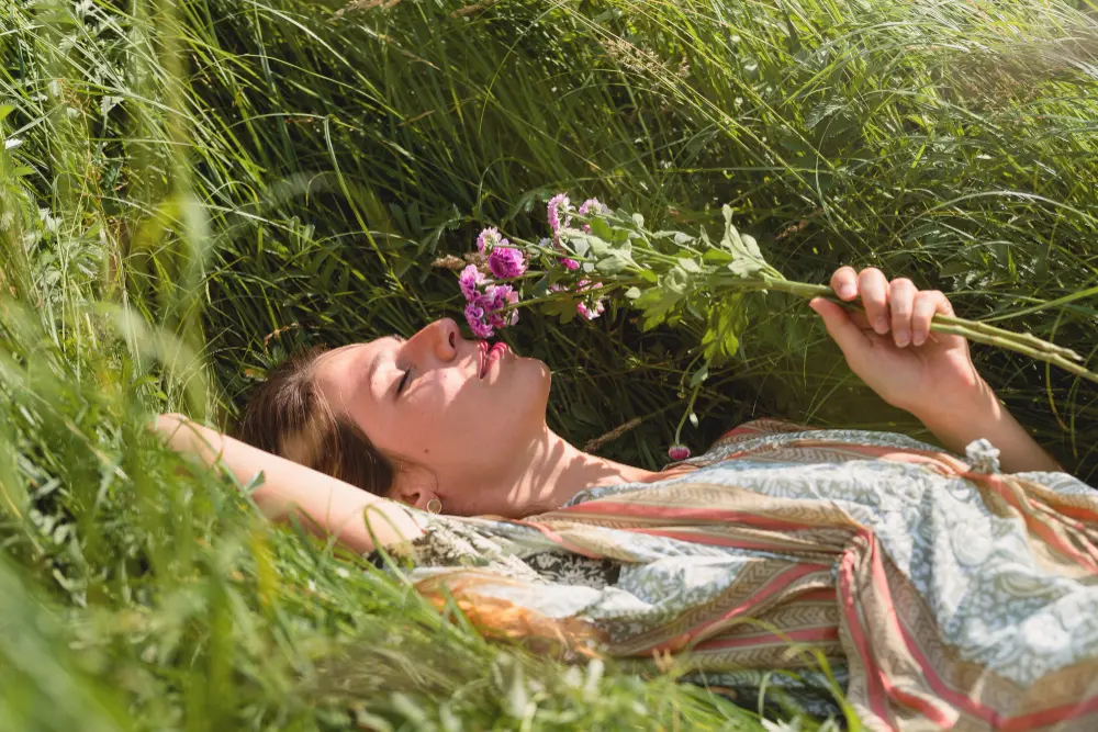 Peaceful woman laying down in a floral meadow, symbolizing the emotional healing and clarity available at Orlando Thrive Therapy.
