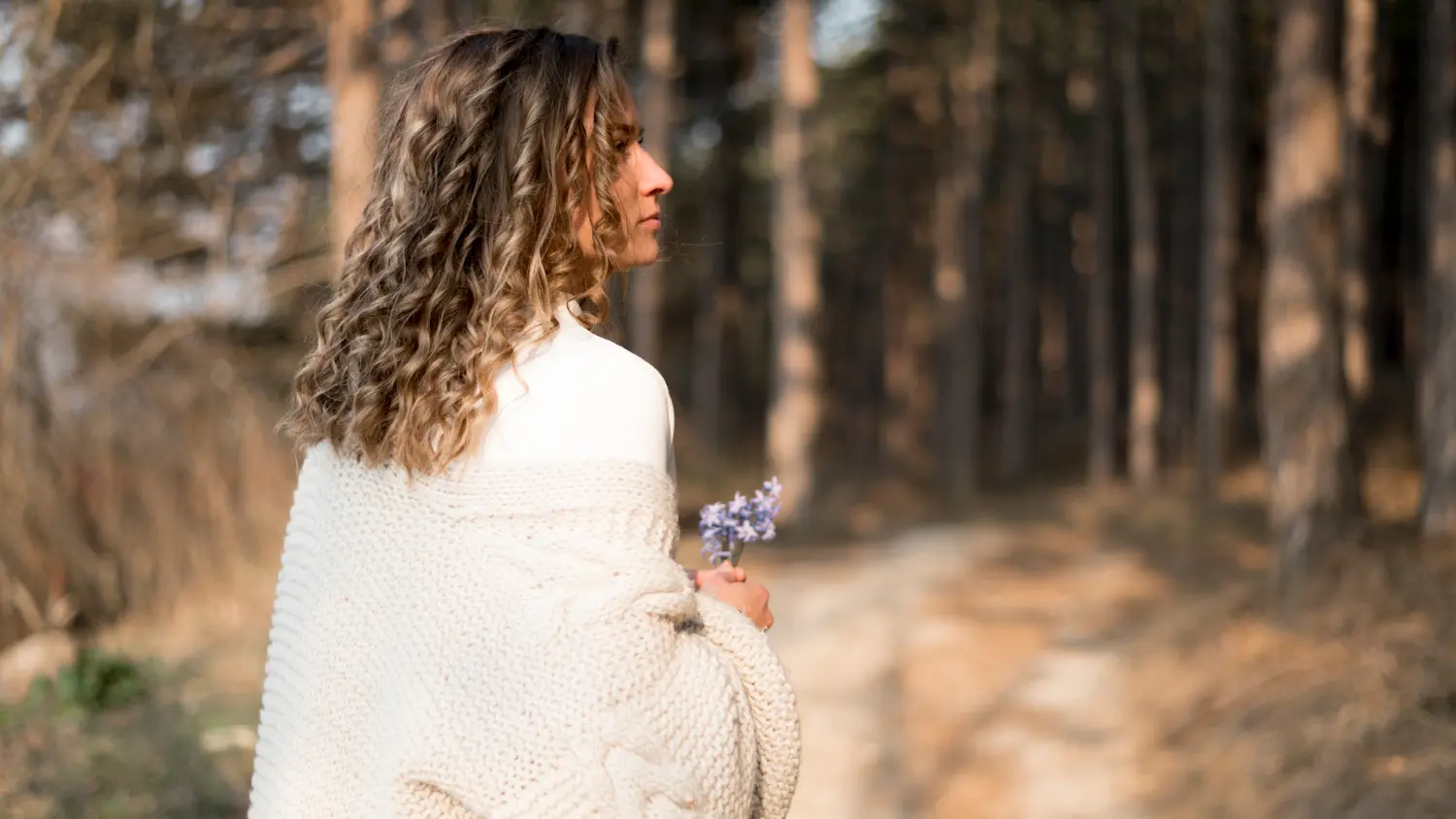 A woman sitting quietly in a peaceful natural setting, reflecting and finding calm as part of her anxiety therapy journey in Orlando.