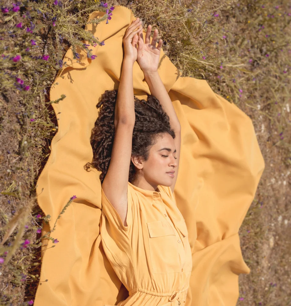 Woman laying in nature while processing difficult emotions, representing the compassionate grief and loss support offered by Orlando Thrive Therapy.
