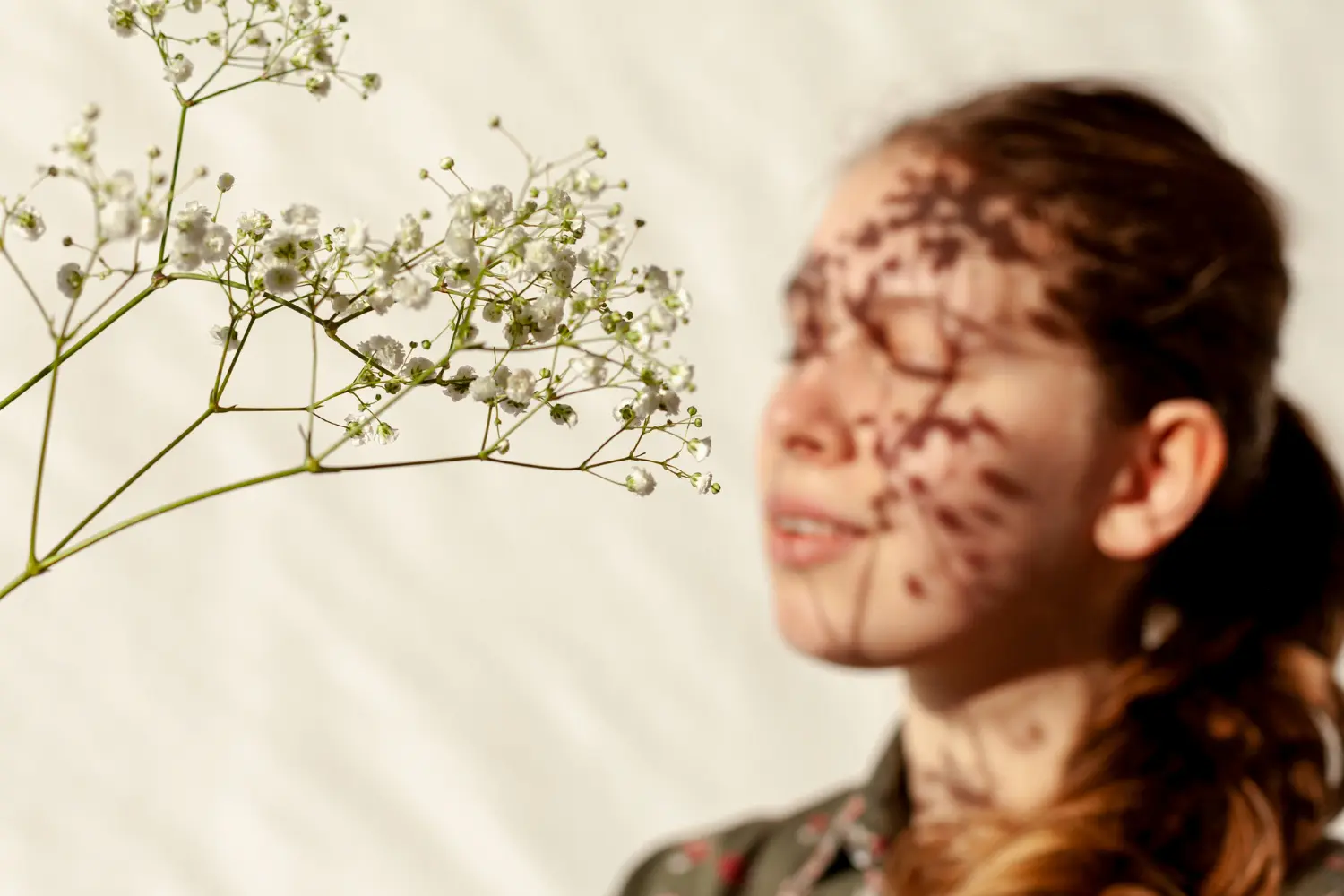 A woman enjoying the sensation of sun on her face, representing the sensory grounding and feeling of safety achieved through trauma-informed counseling.